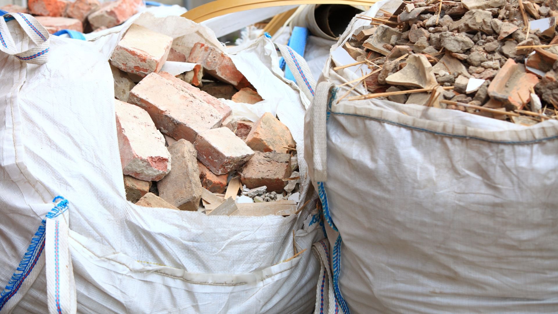 Large white bags filled with broken bricks and construction debris