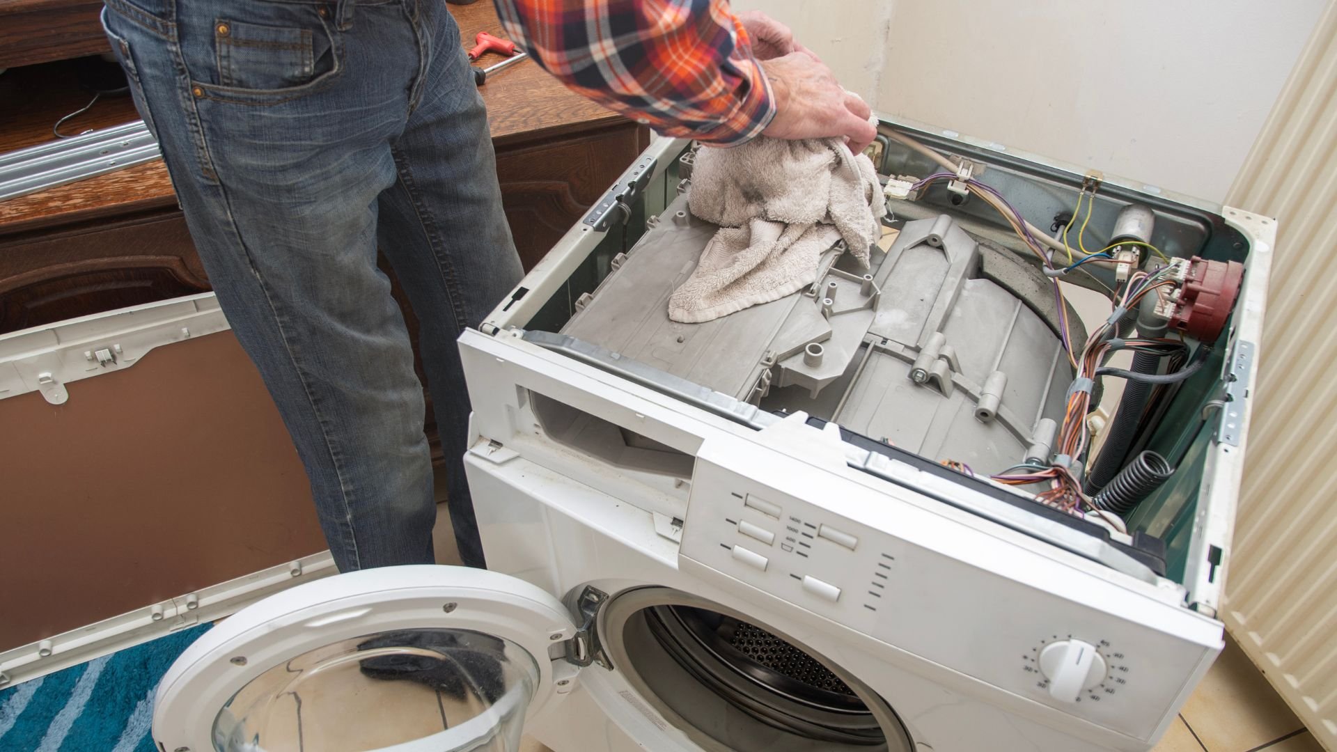 Repairing a washing machine, removing inner components with a towel